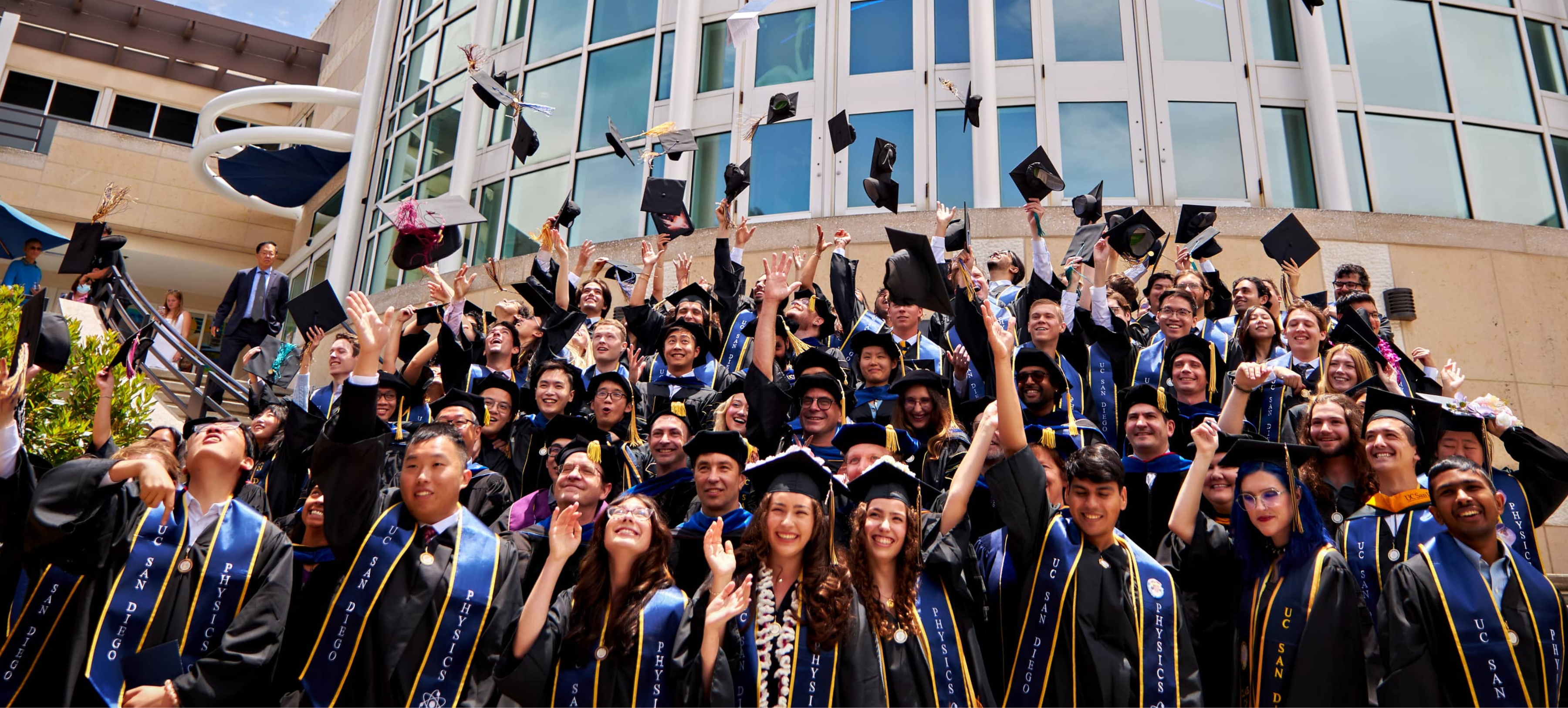 Physics Graduates Celebrating by Tossing Grad Caps In the Air